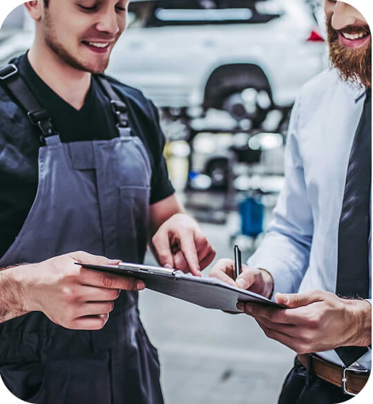 Entretien entre un mécanicien et un client dans un garage automobile